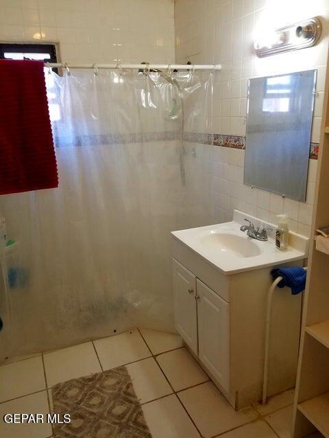 bathroom with tile walls, vanity, tile patterned flooring, and a shower with curtain