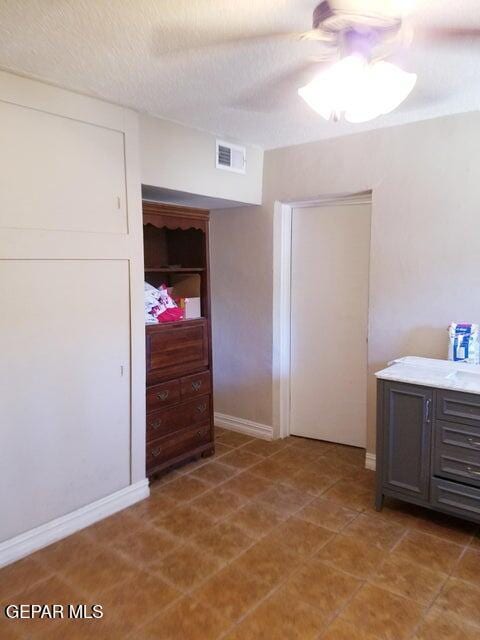 interior space with ceiling fan and a textured ceiling