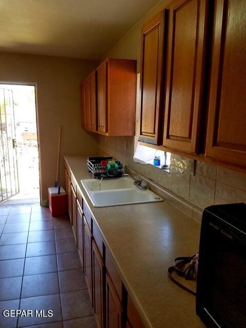 kitchen featuring sink, backsplash, and tile patterned floors