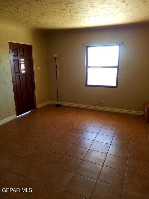 entryway with dark tile patterned flooring and a textured ceiling