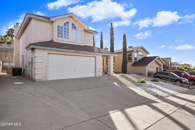 front of property with central AC unit and a garage