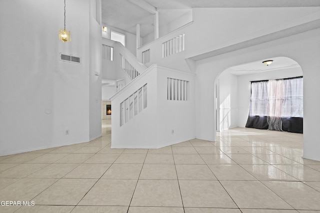 interior space featuring tile patterned flooring and a towering ceiling