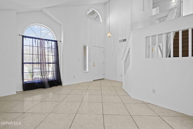 tiled entryway with a towering ceiling