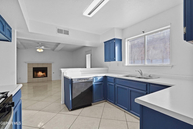 kitchen featuring kitchen peninsula, a tiled fireplace, blue cabinets, dishwasher, and sink