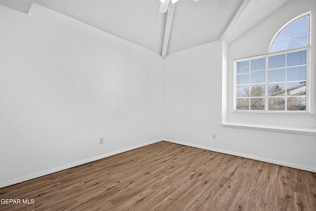 unfurnished room featuring ceiling fan, vaulted ceiling with beams, a textured ceiling, and hardwood / wood-style floors