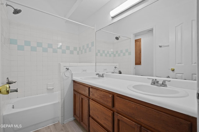 bathroom with tiled shower / bath, hardwood / wood-style floors, and vanity