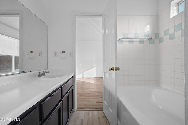 bathroom with hardwood / wood-style flooring, plenty of natural light, vanity, and a bathing tub