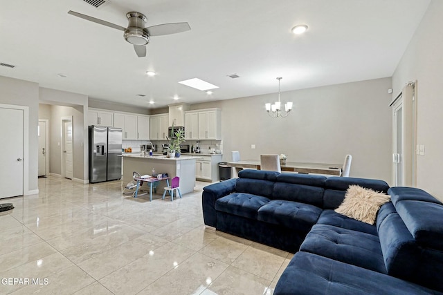 living room featuring ceiling fan with notable chandelier