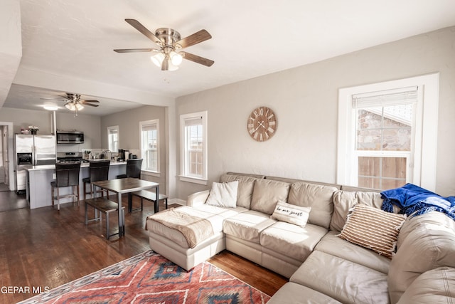 living room with ceiling fan and dark wood-type flooring