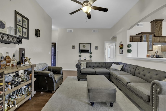 living room featuring dark wood-type flooring and ceiling fan