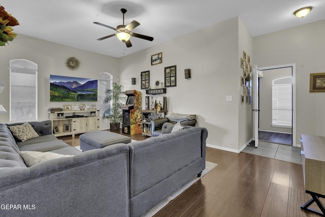 living room with ceiling fan and dark hardwood / wood-style flooring