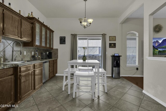 dining area with a chandelier, sink, and light tile patterned floors