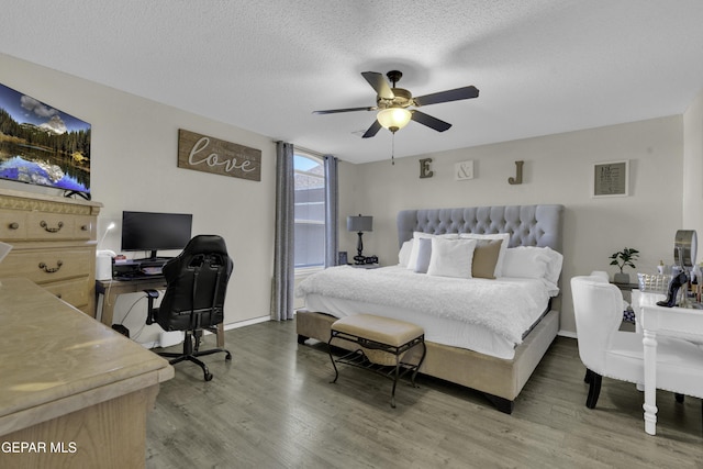 bedroom with ceiling fan, hardwood / wood-style floors, and a textured ceiling