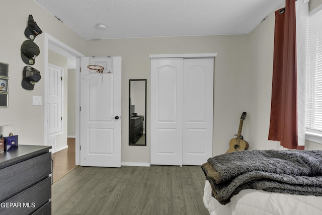 bedroom featuring a closet, a textured ceiling, and light wood-type flooring