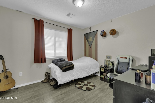 bedroom with hardwood / wood-style flooring and a textured ceiling