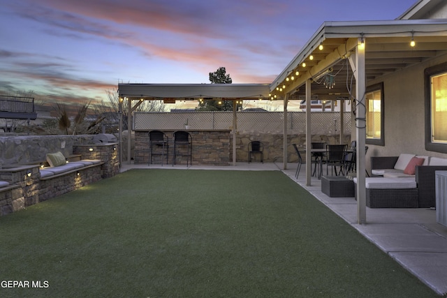 yard at dusk featuring a patio