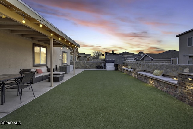 yard at dusk with cooling unit, an outdoor hangout area, and a patio area