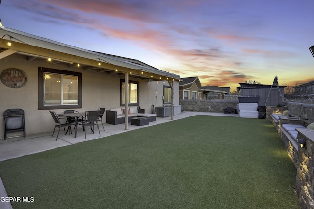 yard at dusk featuring a patio area, a hot tub, outdoor lounge area, and central air condition unit