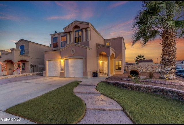 mediterranean / spanish-style home featuring a garage and a yard