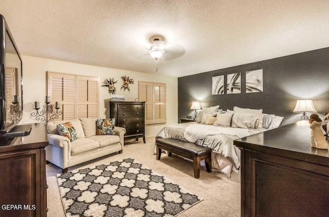 bedroom with ceiling fan, light carpet, a closet, and a textured ceiling