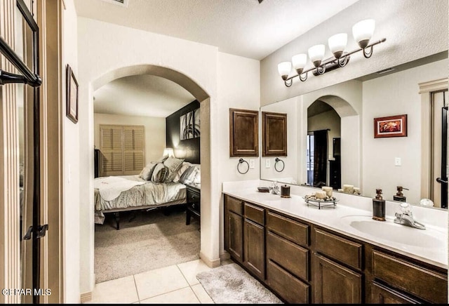 bathroom with a textured ceiling, tile patterned floors, and vanity