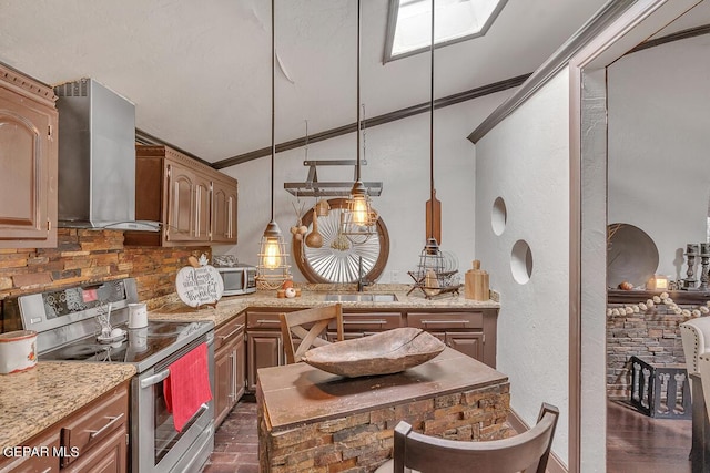 kitchen with appliances with stainless steel finishes, wall chimney exhaust hood, ornamental molding, and sink