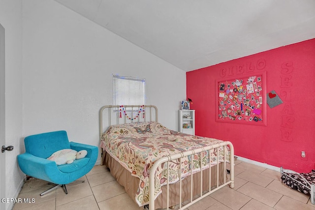 bedroom with lofted ceiling and light tile patterned floors