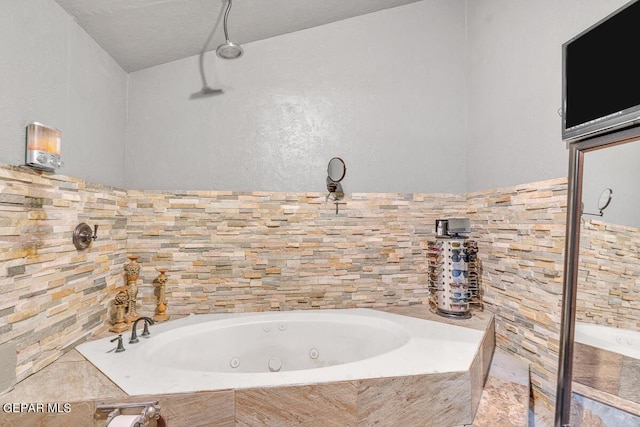 bathroom featuring tiled bath and a textured ceiling