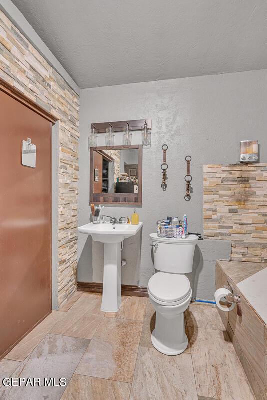 bathroom featuring toilet and a textured ceiling