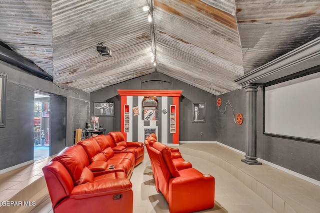 home theater room featuring lofted ceiling and ornate columns