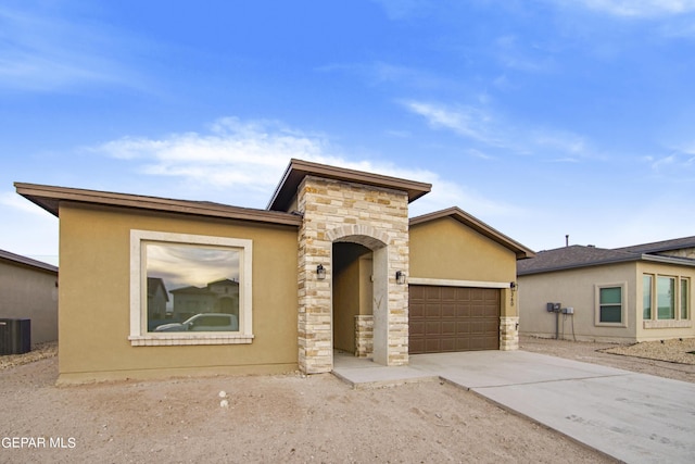 view of front of house with a garage and central AC