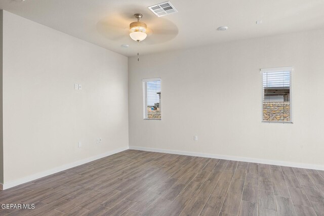 unfurnished room with a wealth of natural light, hardwood / wood-style floors, and ceiling fan