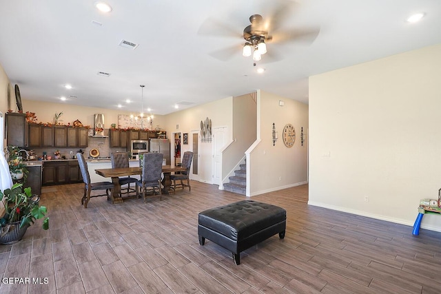 dining area featuring ceiling fan with notable chandelier