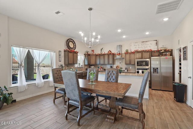 dining space with sink and an inviting chandelier