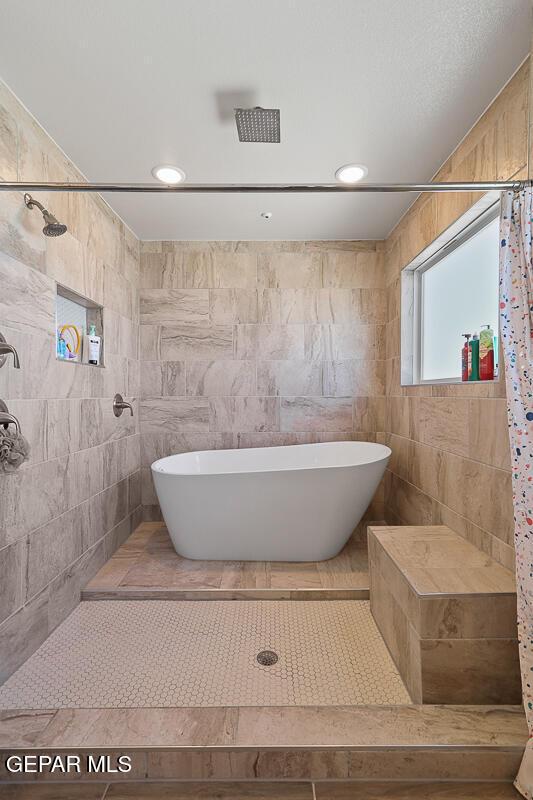 bathroom with independent shower and bath, tile walls, and tile patterned floors