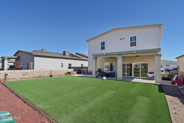 rear view of property with ceiling fan, a lawn, and a patio area