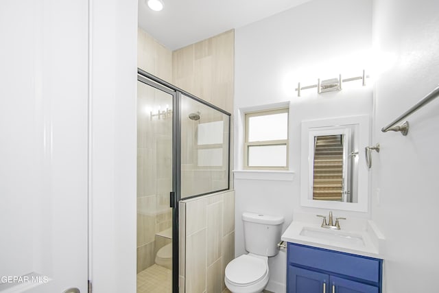 bathroom featuring an enclosed shower, vanity, and toilet