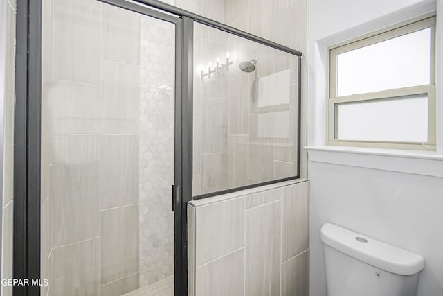 bathroom featuring walk in shower and toilet