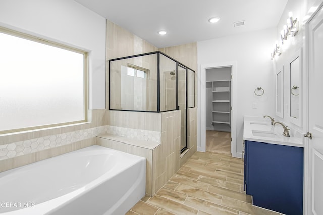 bathroom with vanity and independent shower and bath