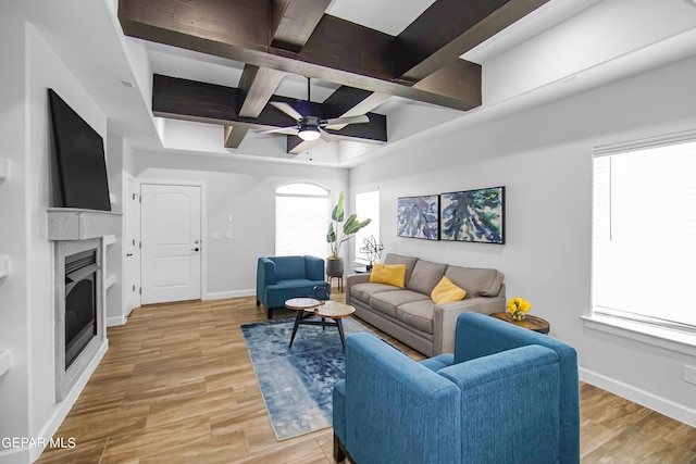 living room featuring coffered ceiling, ceiling fan, light hardwood / wood-style floors, and beamed ceiling