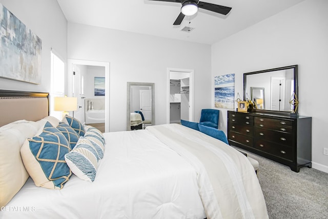 carpeted bedroom with ceiling fan, connected bathroom, a spacious closet, and a closet