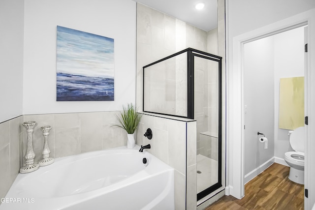 bathroom featuring toilet, separate shower and tub, and hardwood / wood-style floors