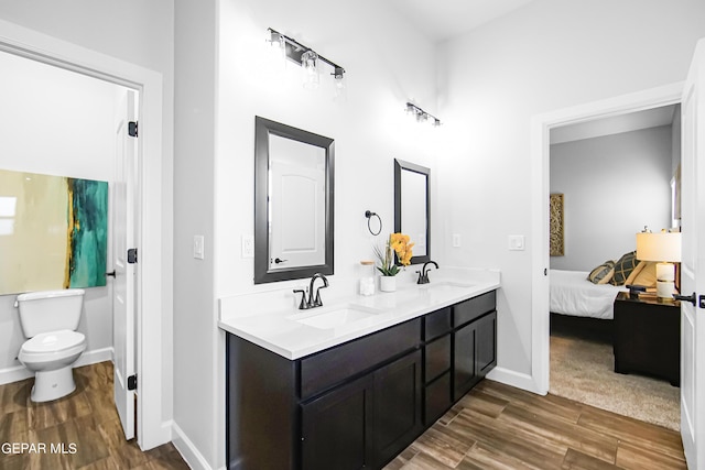 bathroom featuring wood-type flooring, toilet, and vanity