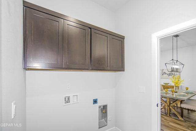 clothes washing area with washer hookup, cabinets, hookup for an electric dryer, and light wood-type flooring