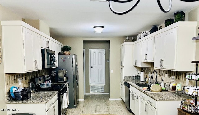 kitchen featuring backsplash, white cabinetry, and stainless steel appliances