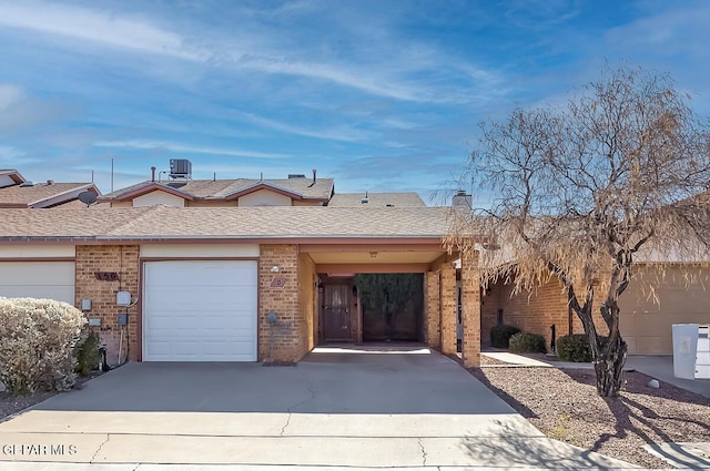 single story home featuring a garage and central AC unit