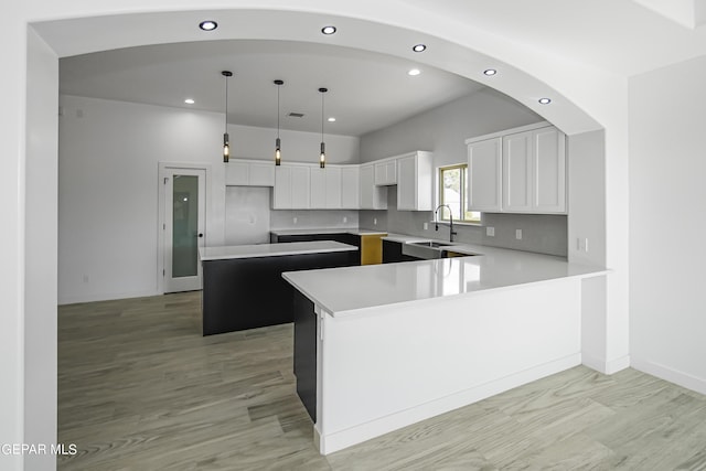 kitchen featuring sink, a center island, hanging light fixtures, white cabinets, and backsplash