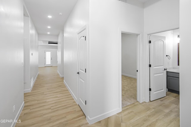 corridor with light hardwood / wood-style floors