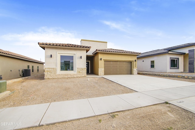 view of front of house with a garage and central air condition unit