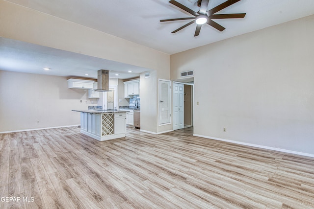 unfurnished living room featuring ceiling fan and light hardwood / wood-style floors